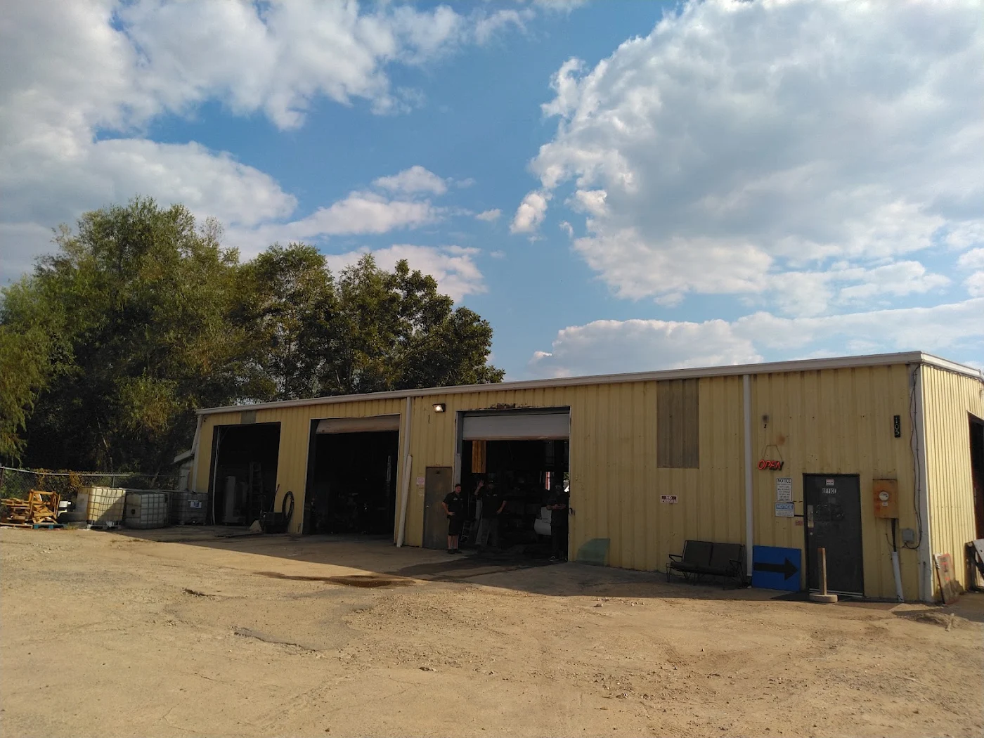 The yellow metal My Garage shop building with open bay doors